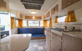Caravan with yellow curtains and a classic interior