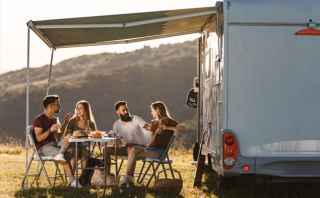 Group of people sitting and talking under the caravan annexe