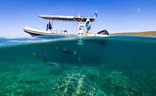 Two people snorkelling next to a boat in Keppel, Yeppoon