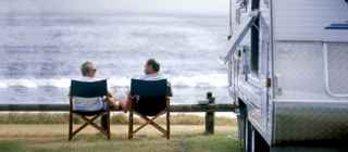 Caravan friends sitting on their chair and enjoying view of the sea